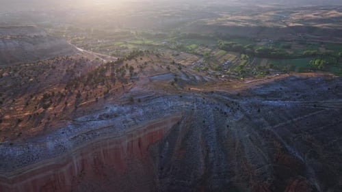Reveal drone shot of rocky mountain with landscape during sunrise