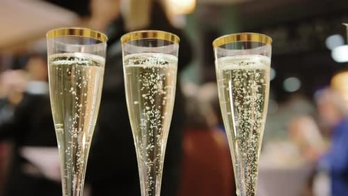 Three Glasses of Champagne Bubbling in Party Setting
