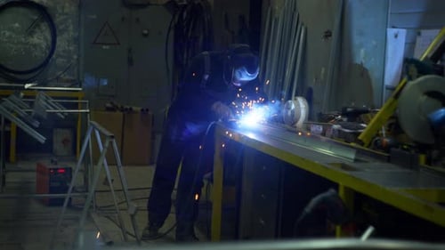 Industrieller Schweißer, der Metallkonstruktionen in einer Fertigungsfabrik baut