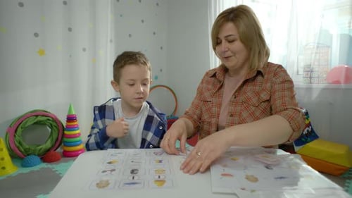 A Preschool Boy Works Individually with a Teacher in Kindergarten