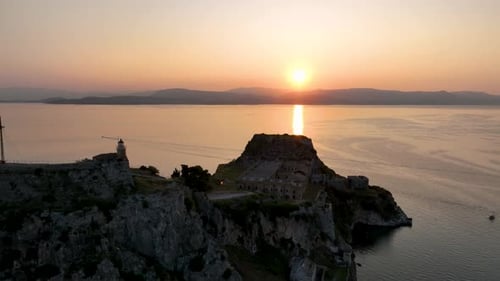 Dramatic Sunrise Over the Old Fortress of Corfu, with the Sun Reflecting on the Calm Waters