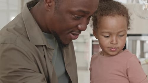 Father and Daughter Bonding with Kisses in Kitchen