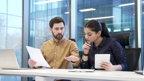 Professional business meeting between two financiers in modern office, discussing important document