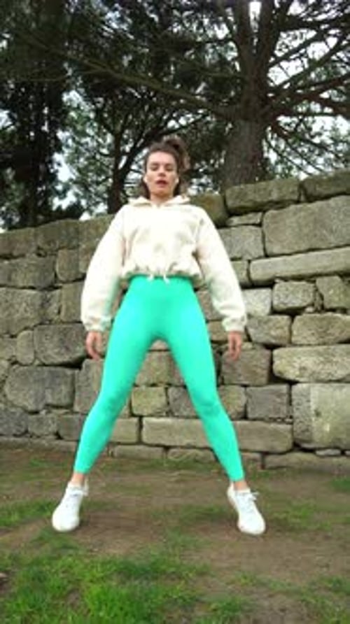 Woman Doing Stretching Exercises in Green Park