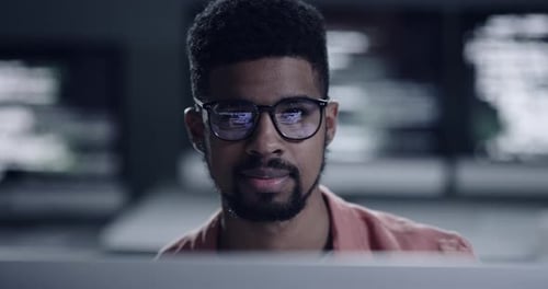 Man Works Late at Computer in Workplace