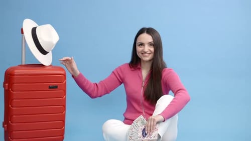Woman Smiling with Luggage and Money