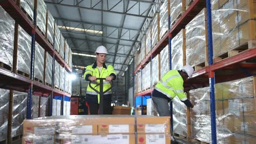 Worker in auto parts warehouse use a handcart to work to bring the box of auto parts