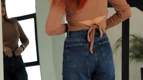 Rear View of Woman Trying to Fit Into Tight Pants After Gaining Weight