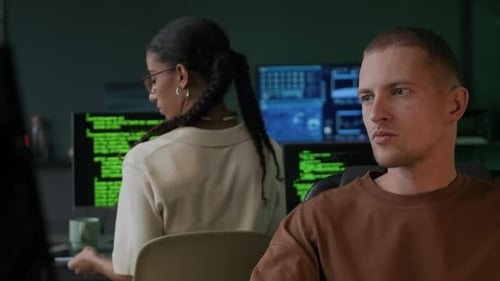 Multiethnische IT-Kollegen, die abends im Büro arbeiten