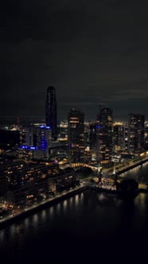 Vertical aerial pan right Puerto Madero towers at night
