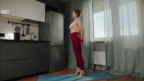 Auburn Haired Woman Stretching at Home in Kitchen