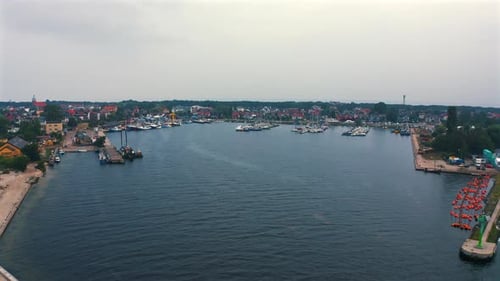 Aerial view of drone flying towards the marina with moored yachts and motorboats