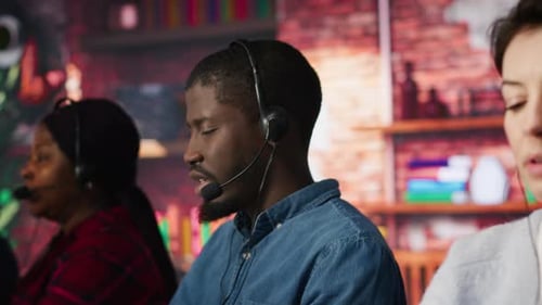 Call Center Staff Members Wearing Headphones Assisting Customers in Office