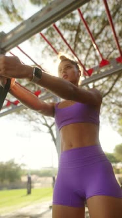 Woman Working Out With Resistance Band in Urban Gym