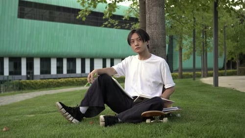 Student Relaxing on Campus Lawn with Books