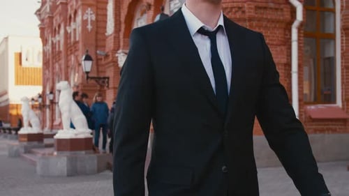 Man in Suit with Tie Walks Past Brick Building Closeup