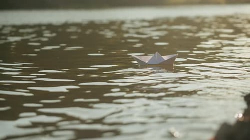 Woman Put Paper Ship Boat on Water in the Park Close Up Origami Paper Crane on a Pond Natural Lake