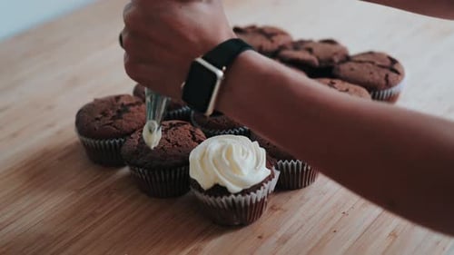 Footage of putting cream on muffins