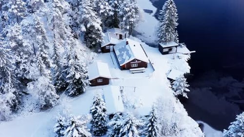 Aerial View Of Snowy Cabin And Forest At Wintertime In Norway.