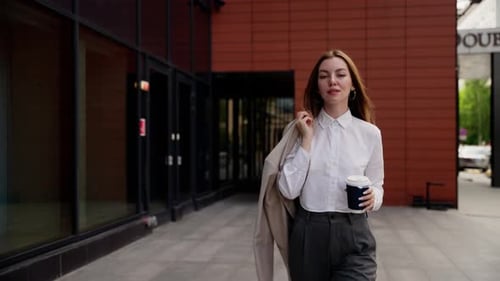Businesswoman Walking with Coffee in Urban Setting
