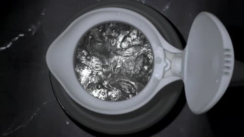 boiling water bubbles come up slow motion in silicone kettle closeup top view
