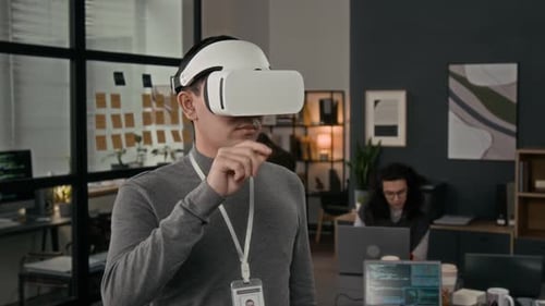 Junger männlicher Produktmanager mit VR-Headset testet Anwendung im Büro