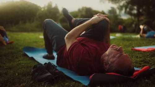 Close up mature man doing workout activity with a group of friends in a public park