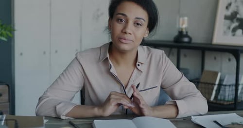 Portrait of African American Lady Speaking and Waving Hand During Virtual Meeting Online From Office