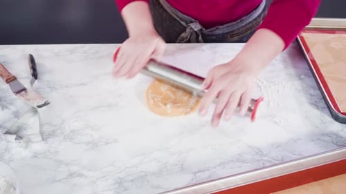 Woman Rolling Out Cookie Dough For Baking