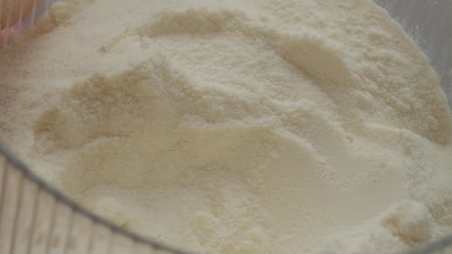 Close up of spoon filling with powdered milk for cooking and baking