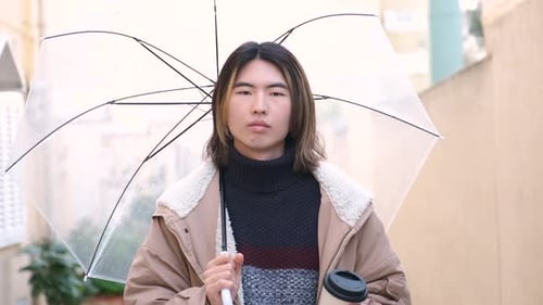 Young Adult Smiling with Umbrella and Coffee