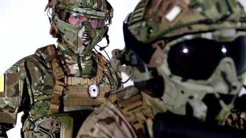 Camouflaged Figures Hold Rifles in a White Studio