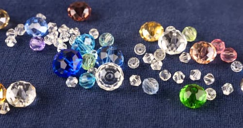 Multi-colored transparent jewelry crystals and rock crystal on blue velvet.
