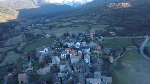 Aerial video over a small town in the Pyrenees in Andorra with the church