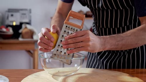 Chef Grating Lemon Zest into Bowl