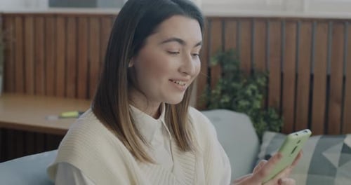 Woman Reacts to News on Mobile Phone