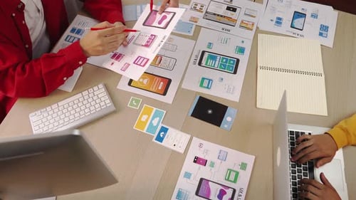 Web designers collaborate on interface design at workplace