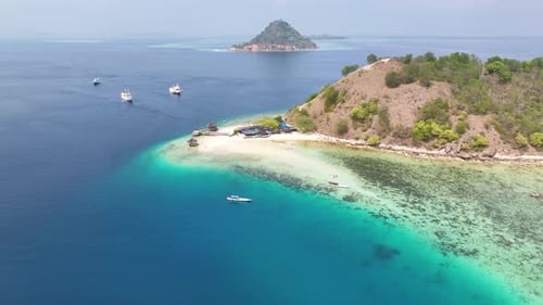 Kelor Island in Komodo, Indonesia. Tropical travel destination with pier and sandy beach.