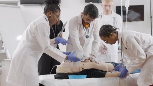 Medical Students Training on Manikin in Hospital Room