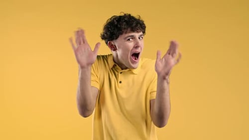 Excited Man Gesturing on Yellow Background