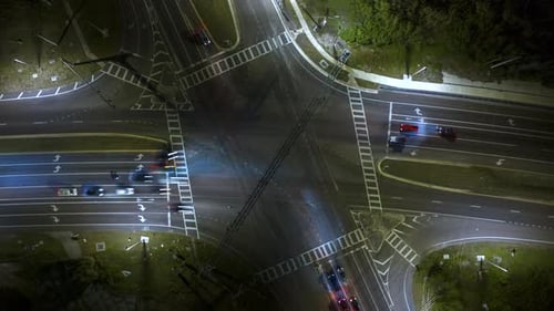 Top View of Large Multilane Road Intersection with Traffic Lights and Moving Cars and Trucks at