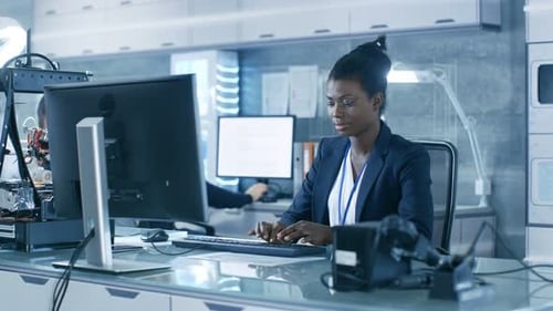 Black Female Scientist Working on a Computer with Her Colleagues at Research Center.