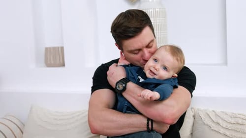 Loving Father Embraces Happy Baby Indoors