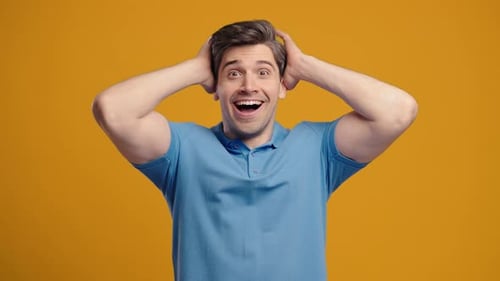 Man Smiling and Reacting Positively on Orange Background