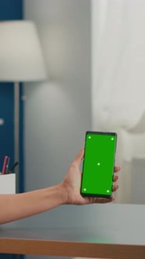 Vertical Video Social Media Woman Holding Touchscreen Phone with Mock Up Green Screen