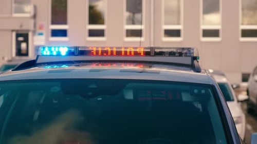 Stationäres Polizeiauto mit blinkenden Notlichtern bei einem Vorfall in der Stadt