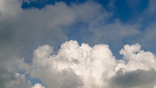 Fluffy White Clouds Flowing Across the Blue Sky