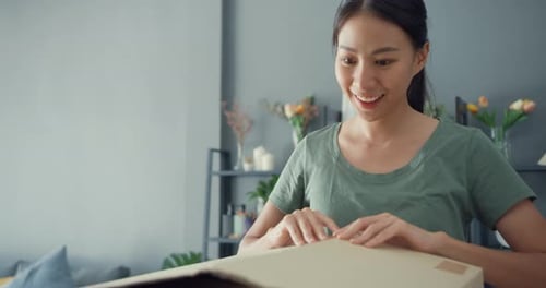 Young Woman Opens a Birthday Gift at Home