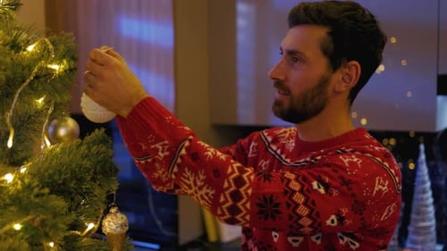 Man Decorating Christmas Tree in Cozy Home Interior