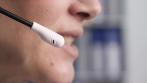 Call Center a Young Woman Talking to a Client Using a Microphone on Headphones While Working in